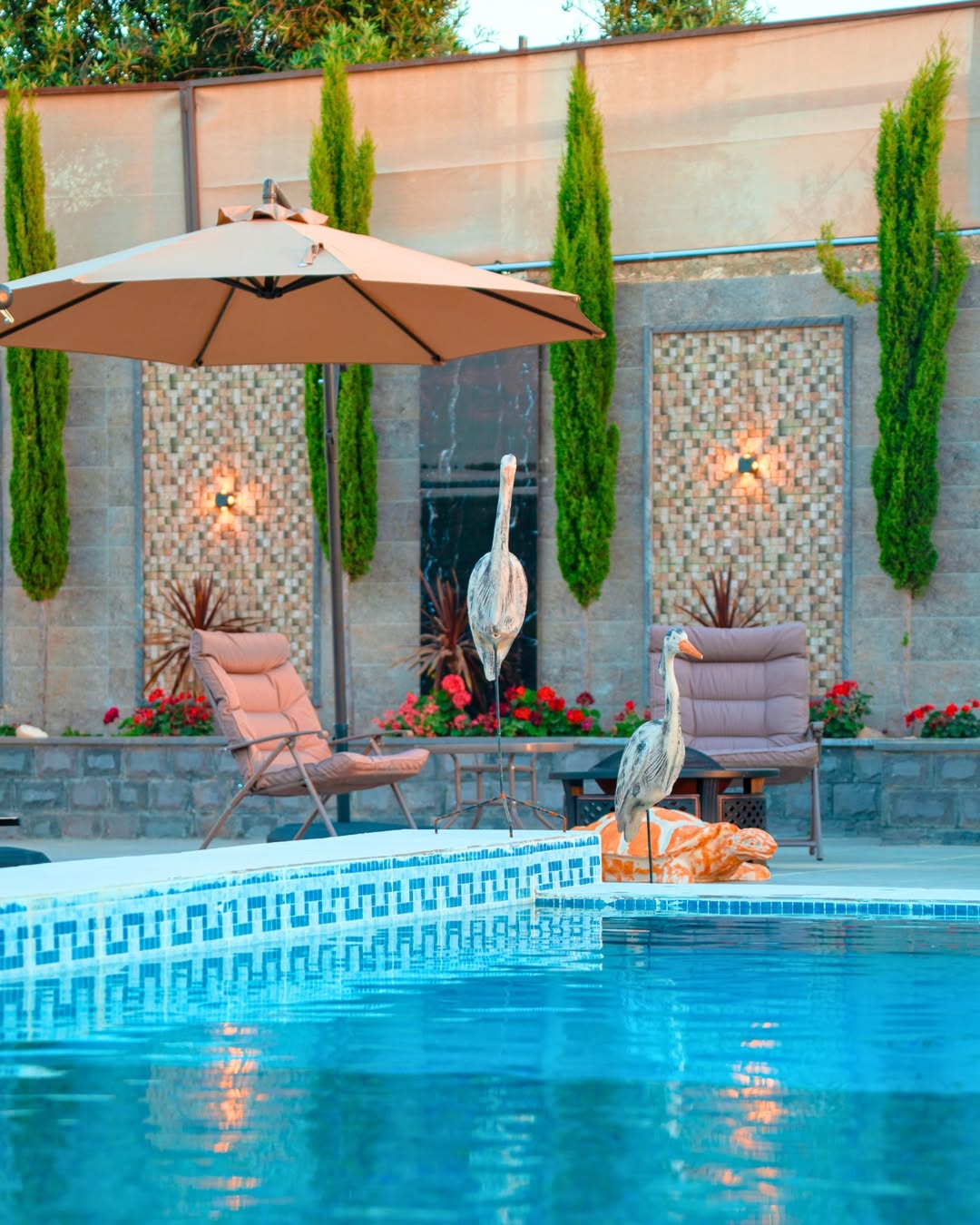 Loungers, parasols and mosaic tile detail beside the RETALISA pool
